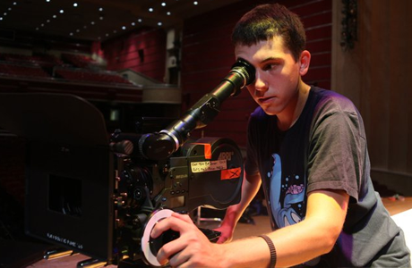 Robert looking into the viewfinder of a large video camera